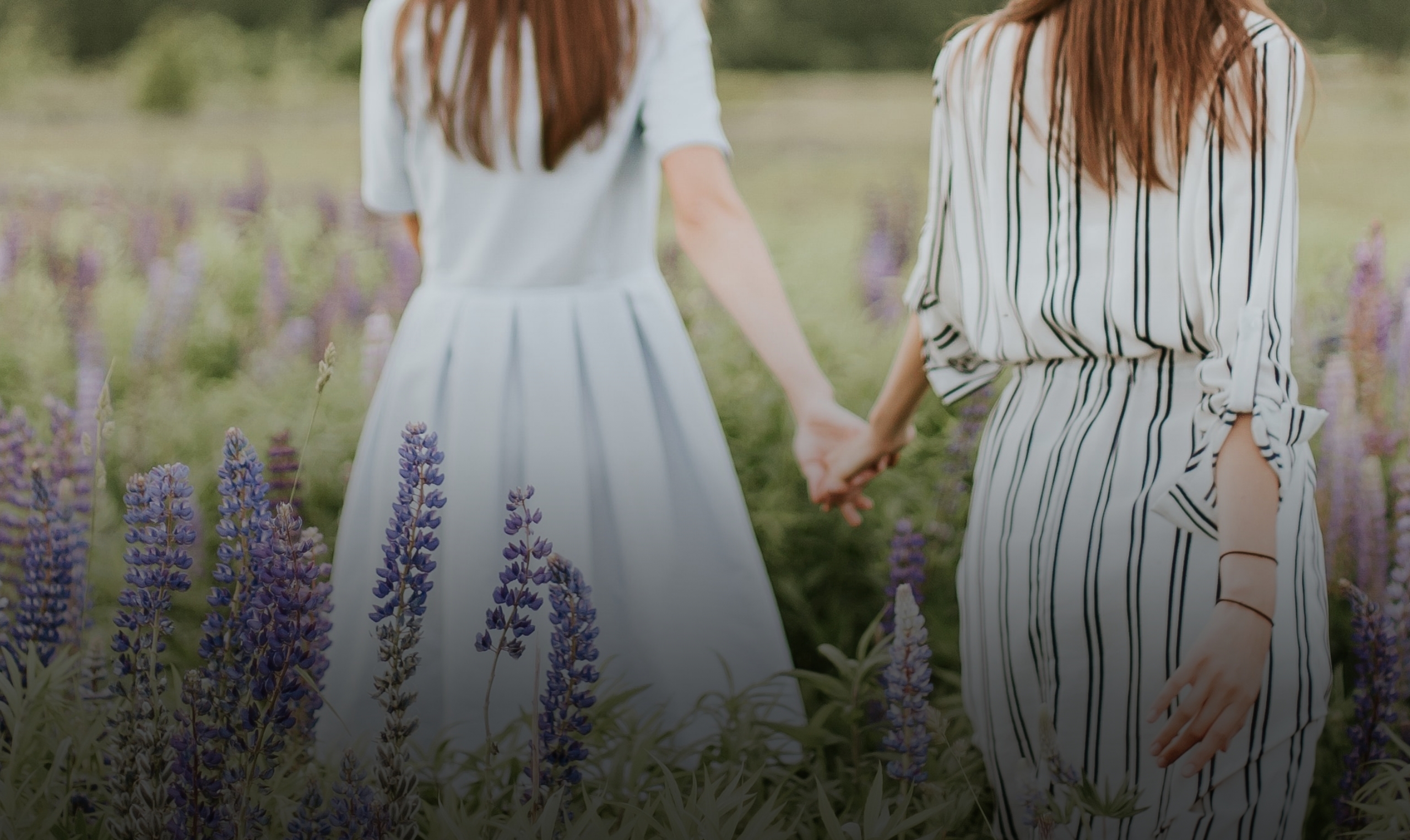 GBI Hamburg Bestatter Zwei Frauen gehen Hand in Hand über ein Lavendefeld